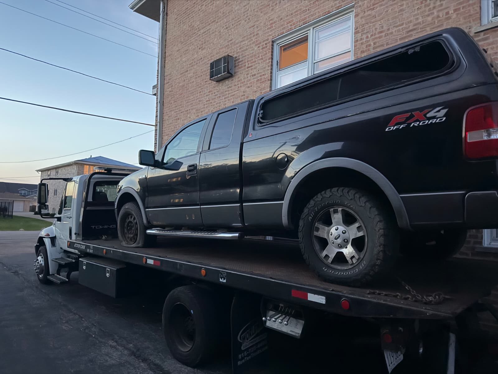 Ford F-150 pickup loaded on a flatbed for junk truck removal